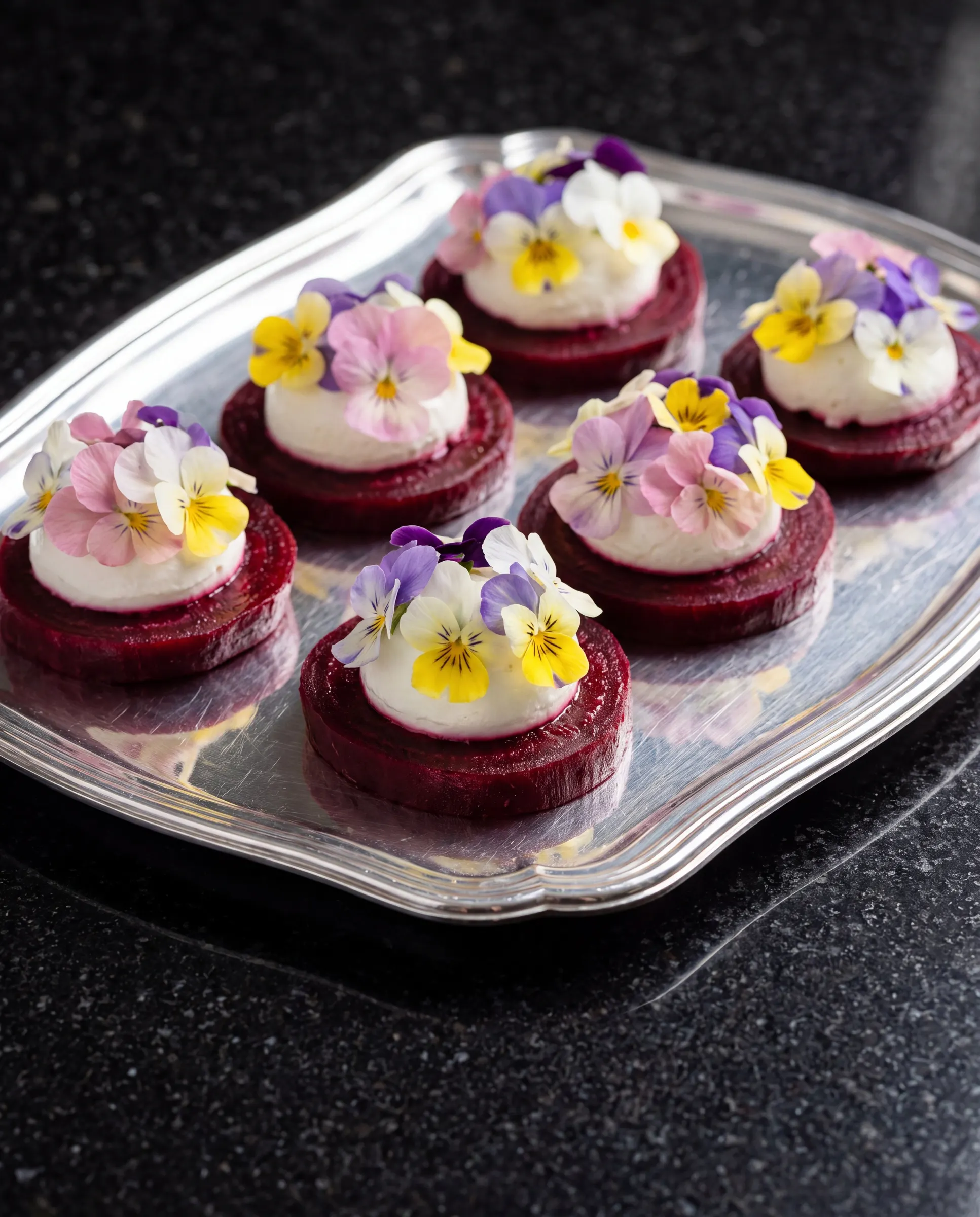 Beetroot canapés topped with edible flowers