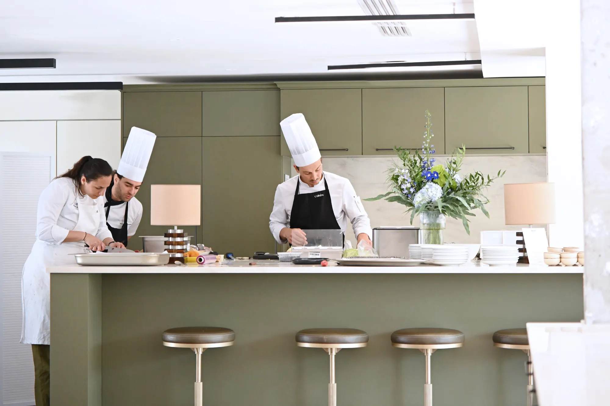 Culinère team preparing around a kitchen island