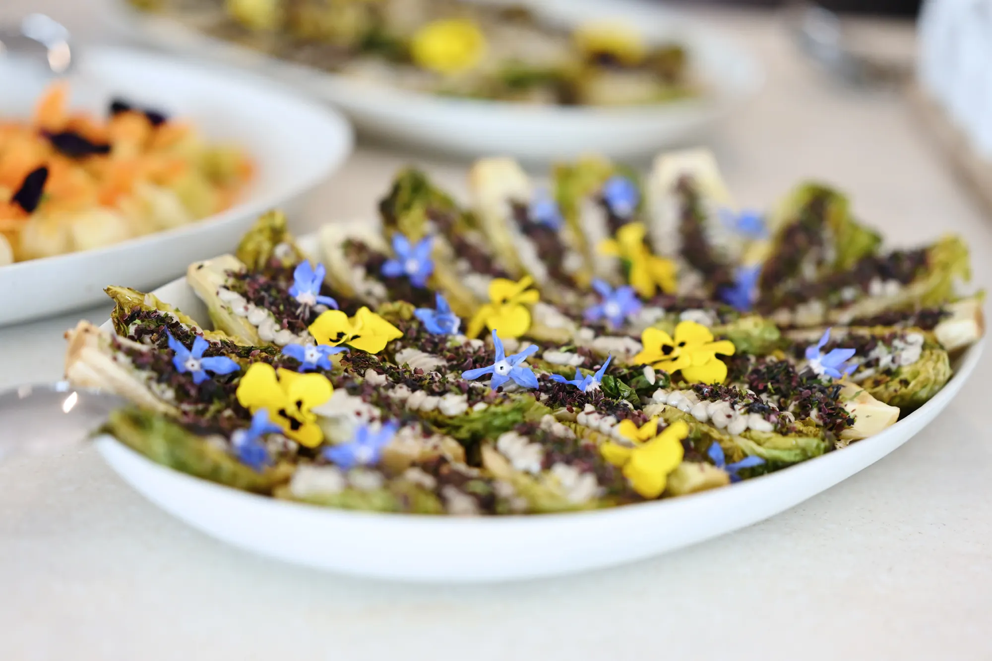 Rows of canapés topped with blue and yellow flowers