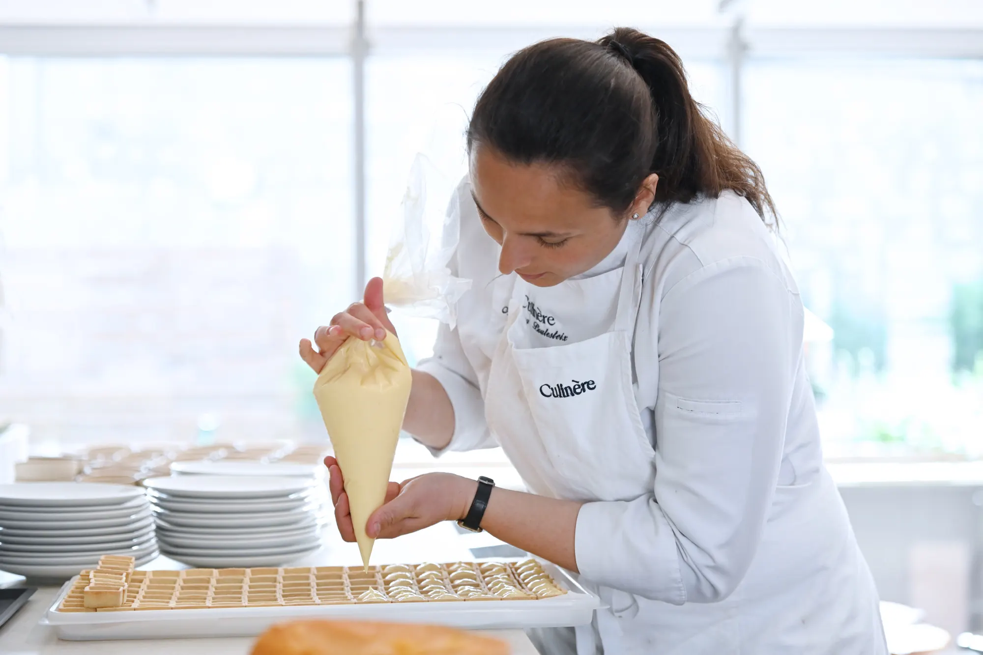 Culinère team member piping tartlets for a breakfast