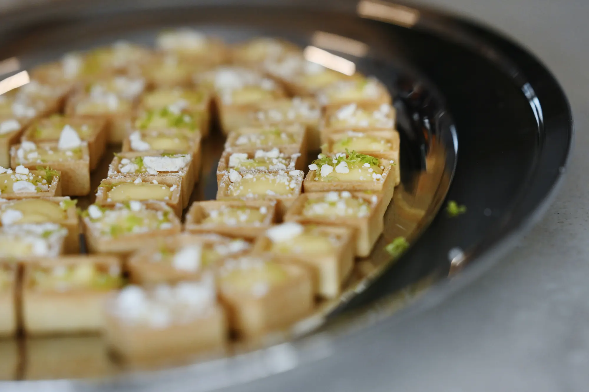 Lemon meringue tartlets presented on a silver platter