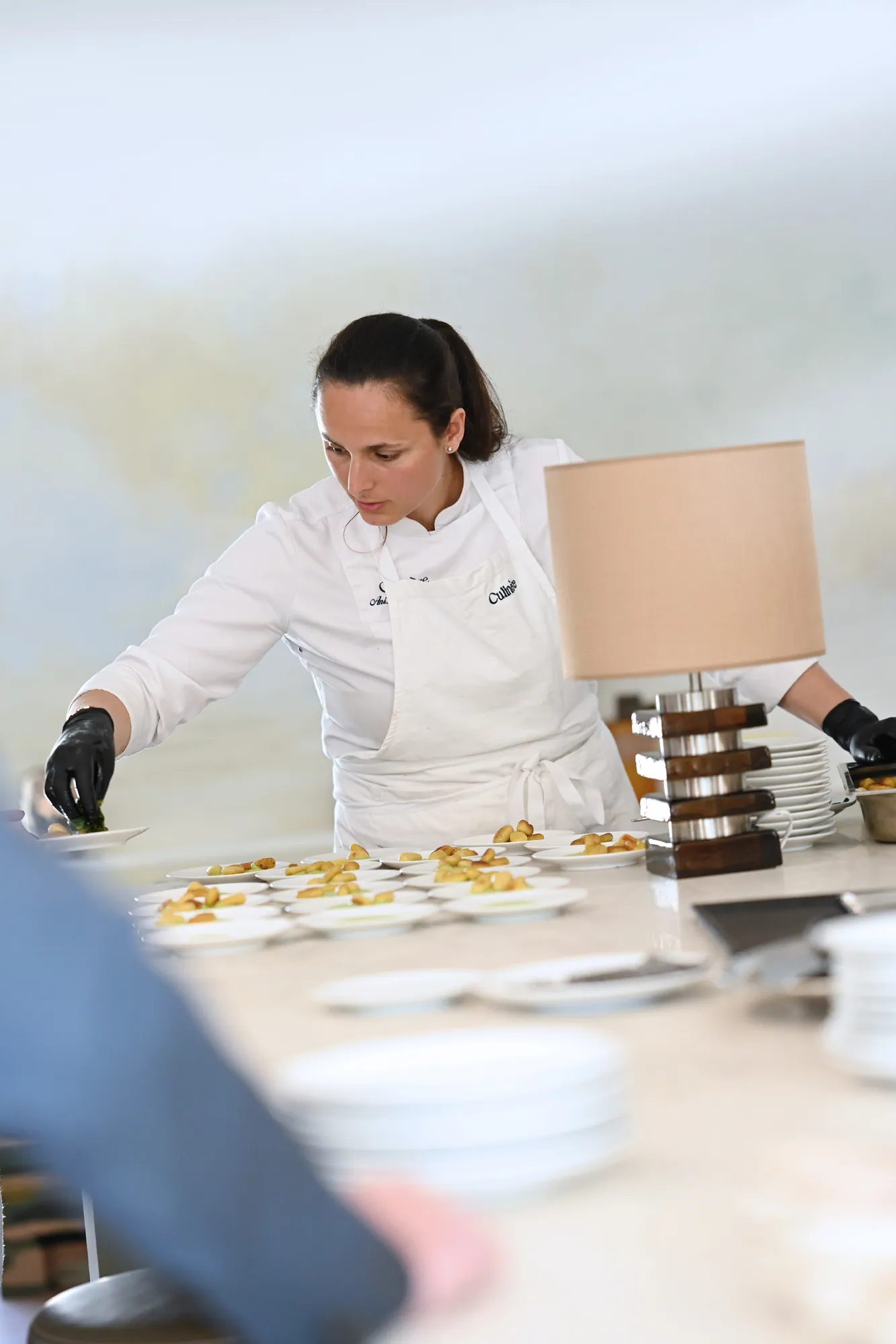Anissa Boulesteix plating several dishes in the kitchen
