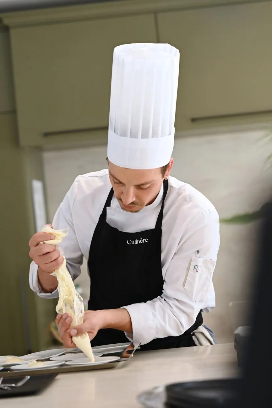 Culinère chef in a workshop, piping bag in hand
